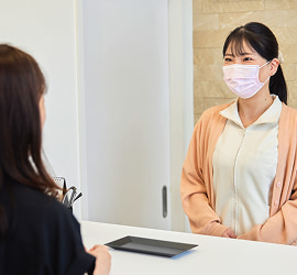お客様に支払いの説明をする「ドーズ美容外科」のスタッフ
